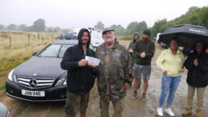 Clive Archer presenting Mark Banks with £100